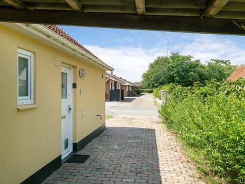 a brick walkway leading to a building with a white door at Holiday Home Øthi by Interhome in Ribe