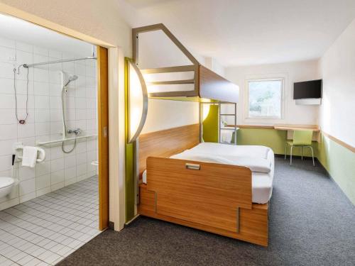 a bedroom with a bunk bed and a bathroom at B&B HOTEL Koblenz-Nord in Mülheim-Kärlich