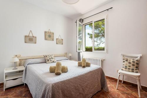 a bedroom with a bed with two teddy bears on it at Villa Gregal in Cala Blanca