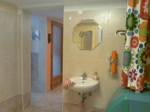 a bathroom with a sink and a mirror at Apartma "Pod Matajurjem" in Kobarid