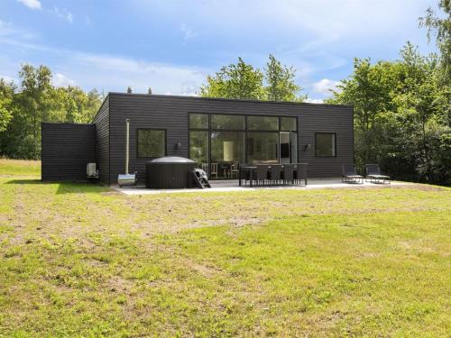 a black tiny house with a large yard at Holiday Home Kiro - 3km from the sea by Interhome in Toftlund
