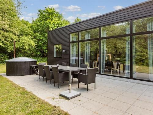 a dining area with a table and chairs and windows at Holiday Home Kiro - 3km from the sea by Interhome in Toftlund