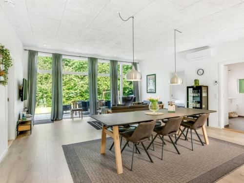 a dining room and living room with a table and chairs at Holiday Home Kiro - 3km from the sea by Interhome in Toftlund
