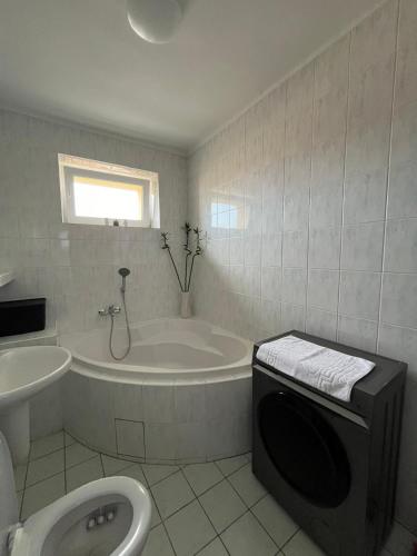 a bathroom with a tub and a toilet and a sink at In City by IQ Apartments in Prešov