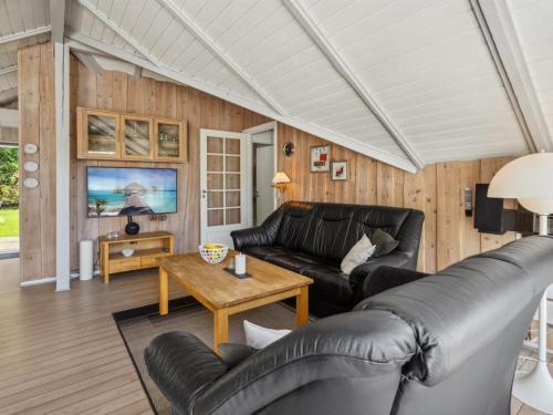 a living room with leather furniture and a table at Holiday Home Ines - 25km from the sea by Interhome in Toftlund