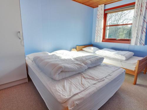 ein Schlafzimmer mit zwei Betten und einer blauen Wand in der Unterkunft Holiday Home Grette - 1-5km from the sea by Interhome in Vejers Strand