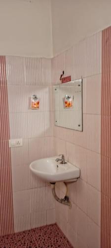 a bathroom with a sink and a mirror on the wall at Mattuppavu Beach House in Vilinjam