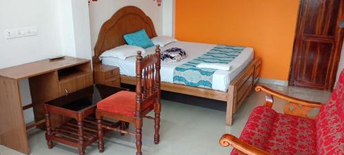 a bedroom with a bed and a desk and a chair at Mattuppavu Beach House in Vilinjam
