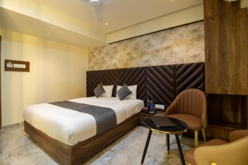 a hotel room with a bed and a chair at Hotel Ratna Paradise Thane West in Thane