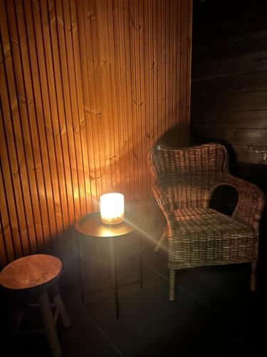 a candle sitting on a table next to a chair at Aava Riverside in Rovaniemi