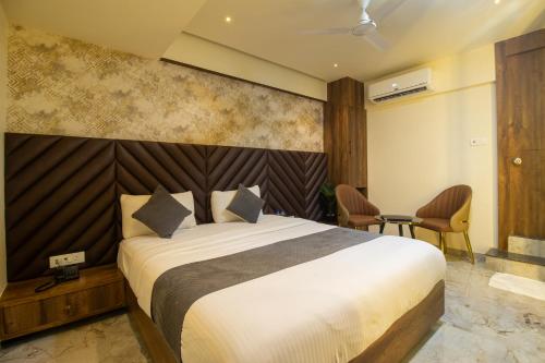 a bedroom with a bed and a table and chairs at Hotel Ratna Paradise Thane West in Thane