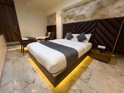 a bedroom with a large bed and a desk and chair at Hotel Ratna Paradise Thane West in Thane