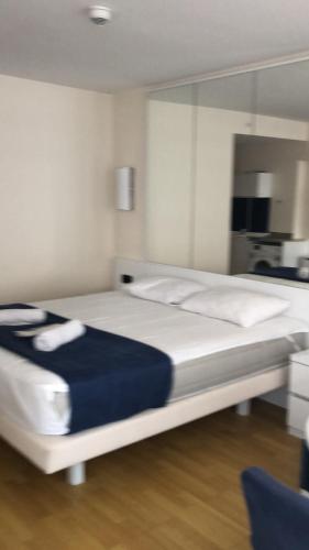 a bedroom with a large white bed with blue sheets at Studio Suite with balcony in Batumi