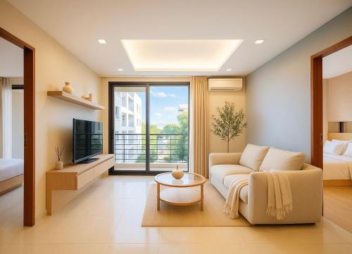 a living room with a couch and a tv at Kamalaya 2BR Balcony Suite at Kamala Beach in Kamala Beach