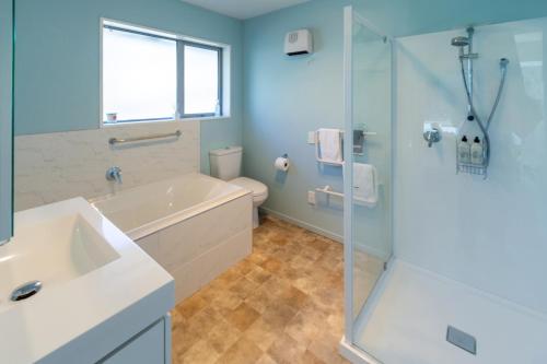 Un baño con bañera, lavabo y ducha. en Your Home Away From Home on Barrington Street, en Christchurch