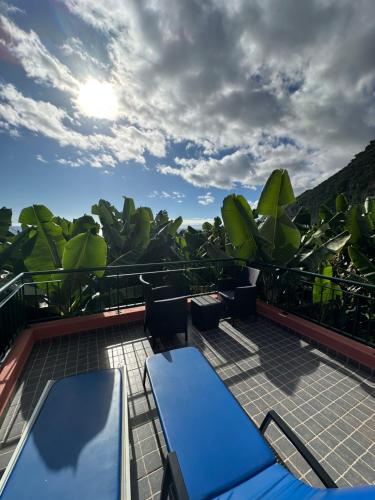 a deck with chairs and tables on a balcony at Casa dos Anjos in Ponta do Sol