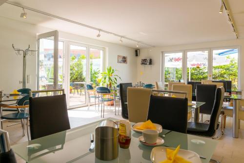 a dining room with tables and chairs and windows at Hotel Am Müritzhafen garni in Waren