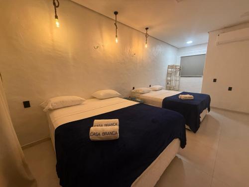 two beds in a room with a sign on it at Casa Branca Mediterrânea in Barra Grande