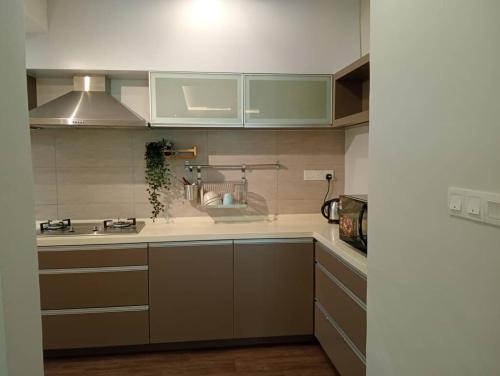 a kitchen with green and white cabinets and a sink at Lumut Valley in Lumut