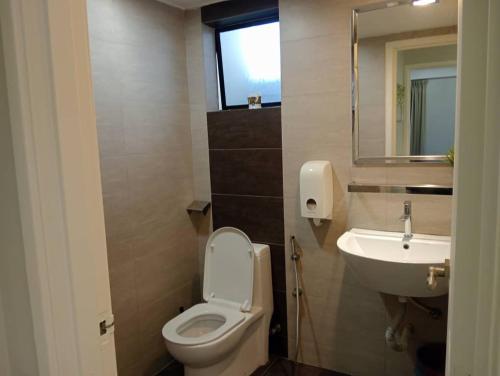 a bathroom with a white toilet and a sink at Lumut Valley in Lumut