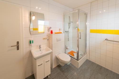 a bathroom with a toilet sink and a shower at Hotel Am Müritzhafen garni in Waren