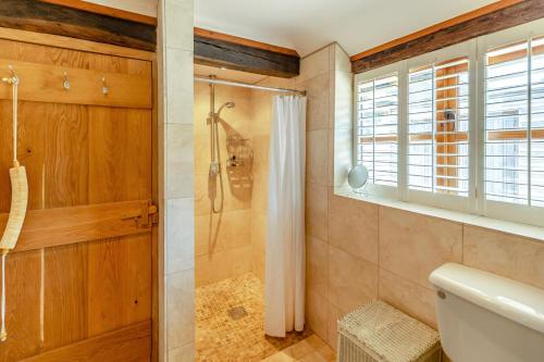 a bathroom with a shower and a toilet at Blackford Farm Cottage in Warbleton