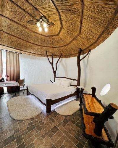 a bedroom with a bed and a tree on the wall at Ecopark VII NEBO in Kirovskoye