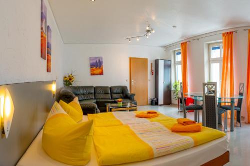 a large yellow bed in a living room at Hotel Am Müritzhafen garni in Waren