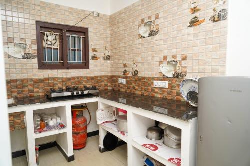 a kitchen with a counter and a refrigerator at Climate Dull - Homestay Villa in Ketti