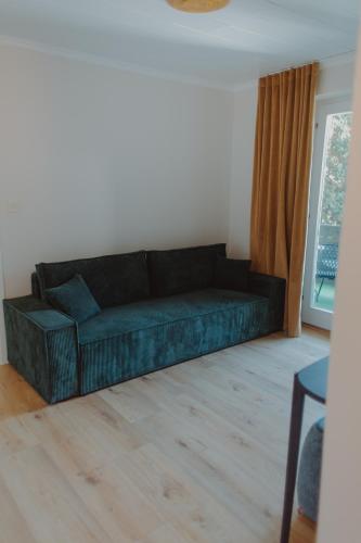a black couch in a living room with a window at Haggn&Co in Neukirchen