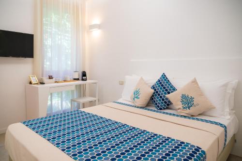 カプリにあるCapri Koral Guest Houseのベッドルーム1室(大型ベッド1台、青と白の枕付)