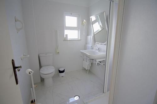 a white bathroom with a toilet and a sink at WOT Algarve in Almancil
