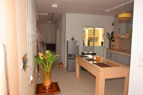 Una cocina con una mesa y un jarrón con flores. en Nenuphar, en Dakar