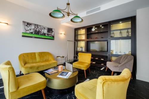 a living room with yellow chairs and a table at Best Western Hôtel Journel Antibes Juan-les-Pins in Antibes