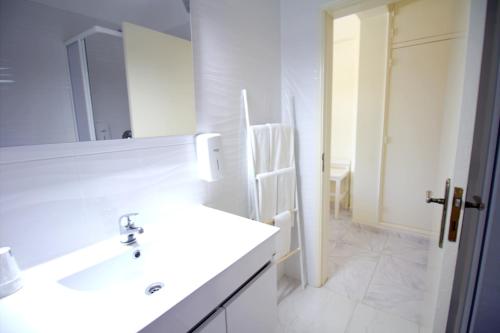 a white bathroom with a sink and a mirror at WOT Algarve in Almancil