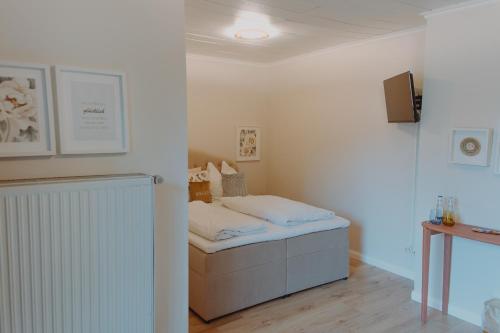 a bedroom with a bed and a tv on a wall at Haggn&Co in Neukirchen