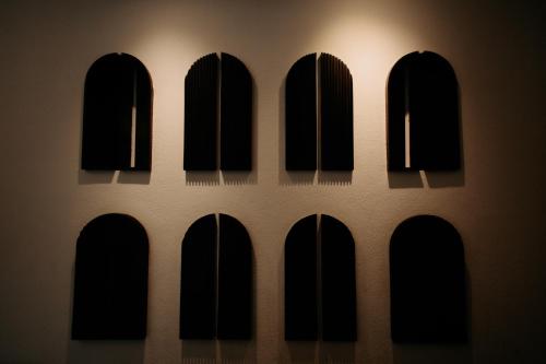 a row of black windows in a wall with a light at Viraam Estate by RÊVE in Assagao