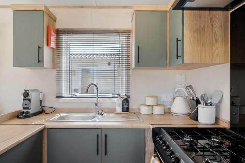 West DownにあるBeachy Lodge with Deck & Parking nr Ilfracombeのシンクとコンロのあるキッチン