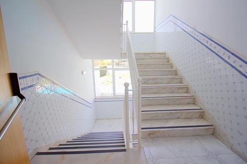 a staircase in a white room with a window at WOT Algarve in Almancil