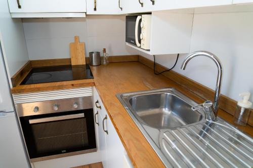 a small kitchen with a sink and a microwave at Piso Luminoso A Metros De La Plaza De Las Flores in Murcia