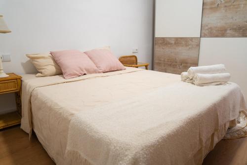 a bedroom with a large bed with pink pillows at Piso Luminoso A Metros De La Plaza De Las Flores in Murcia