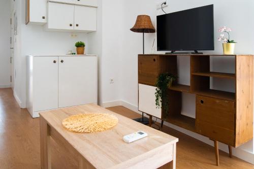 a living room with a tv and a table at Piso Luminoso A Metros De La Plaza De Las Flores in Murcia