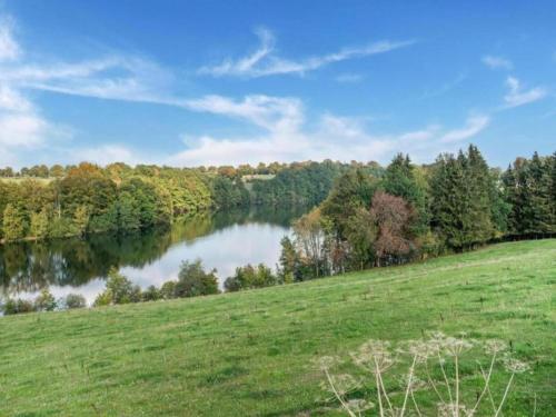 a grassy field with a river in the background at Large Home with Sauna, Ovifat in Ovifat