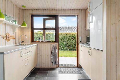 a kitchen with a door leading to a patio at 40607-Juelsminde-Pilevaenget-16 in Snaptun