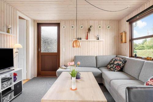 a living room with a couch and a table at 40607-Juelsminde-Pilevaenget-16 in Snaptun