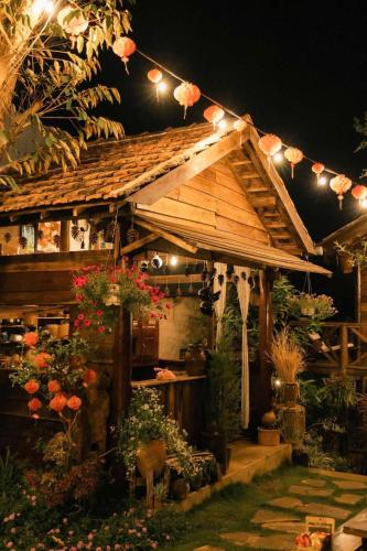 a wooden house with flowers and lights on it at Ôna's House - Homestay Pleiku in Pleiku