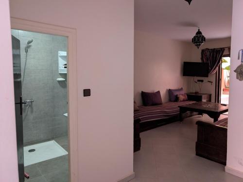 a living room with a couch and a shower at apartement in tamraght in Agadir