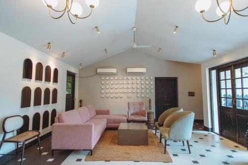 a living room with a pink couch and chairs at Viraam Estate by RÊVE in Assagao