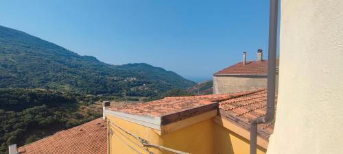 a view from a yellow building with mountains in the background at Lumira Vista - Borgo in Sangineto