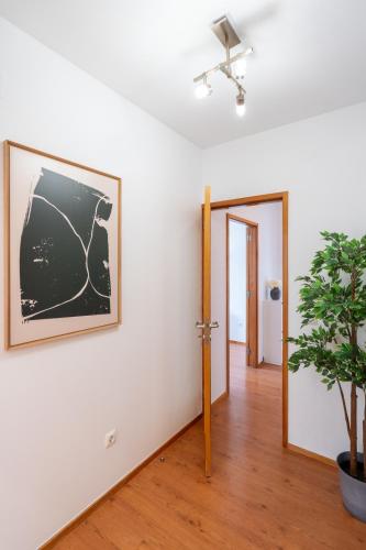 a room with a plant and a picture on the wall at Bright Flat with Balcony & Garage by HostWise in Oliveira do Douro